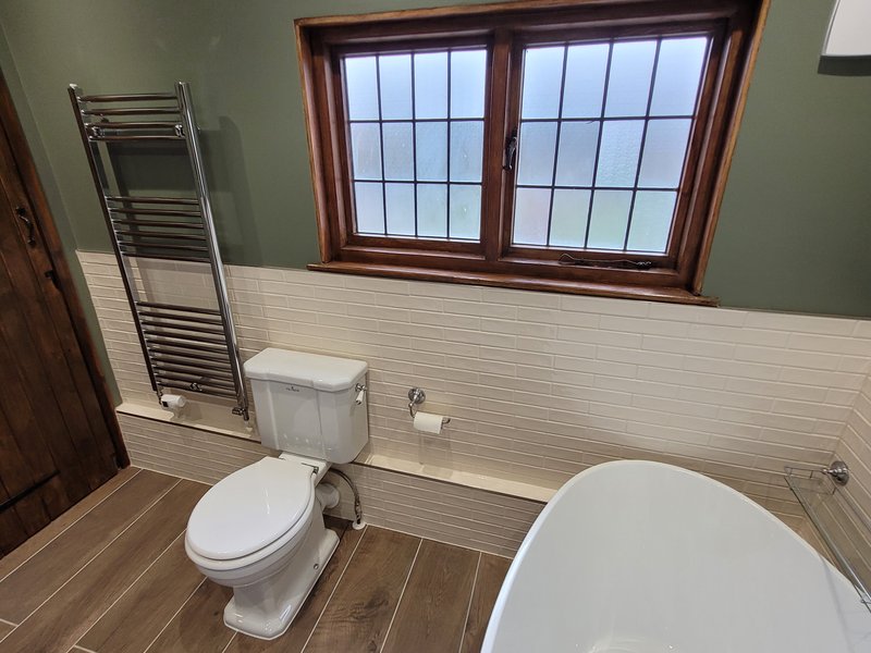 Window facing view showing towel radiator, WC, and freestanding bath Great Bardfield CM6 natural light