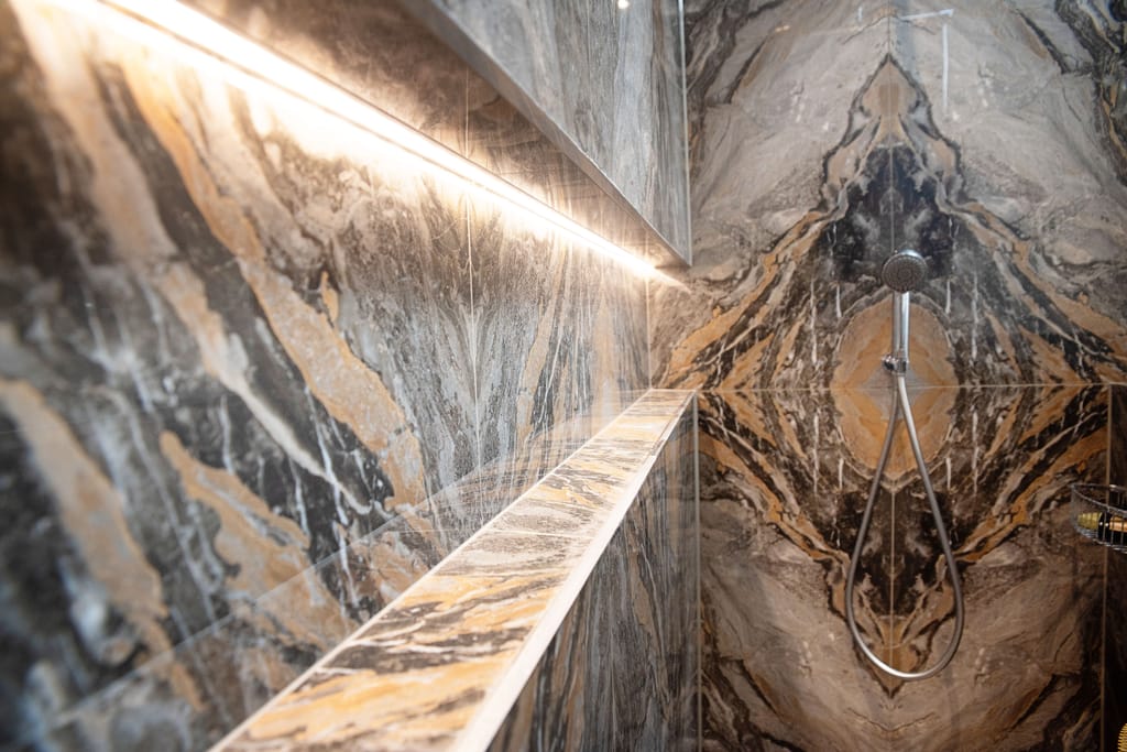 Infinity niche with IP67 rated recessed lighting and Ca Pietra Nero bookmatched tiles Halstead CO9 Essex wetroom feature